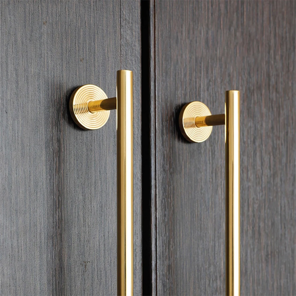 Minimalist brass concentric ring handles by Brass Essence, close-up showing sleek, modern design with circular rings and smooth finish.