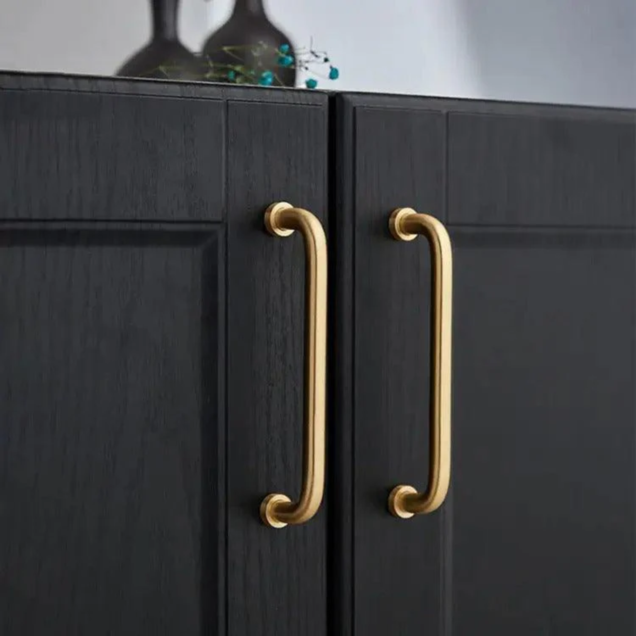 Minimalist solid brass curved handle by Brass Essence, showcasing smooth, polished surface and elegant design for furniture or cabinetry.