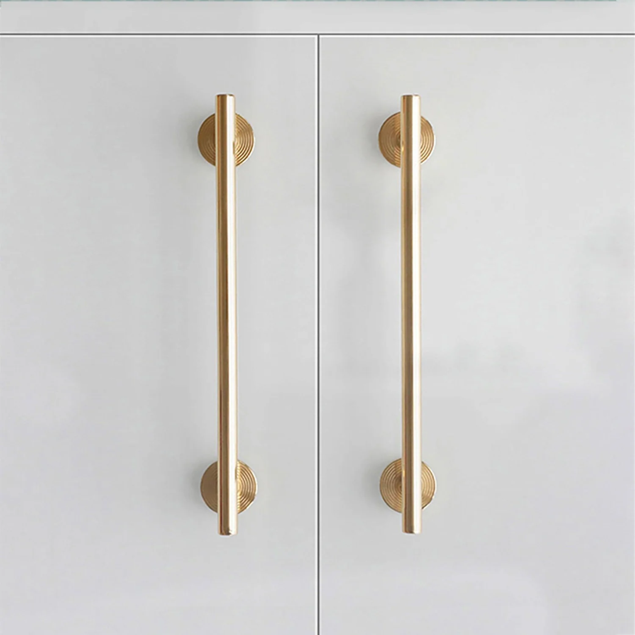 Minimalist brass concentric ring handles by Brass Essence, showing close-up of sleek, modern design with circular shapes and polished finish.