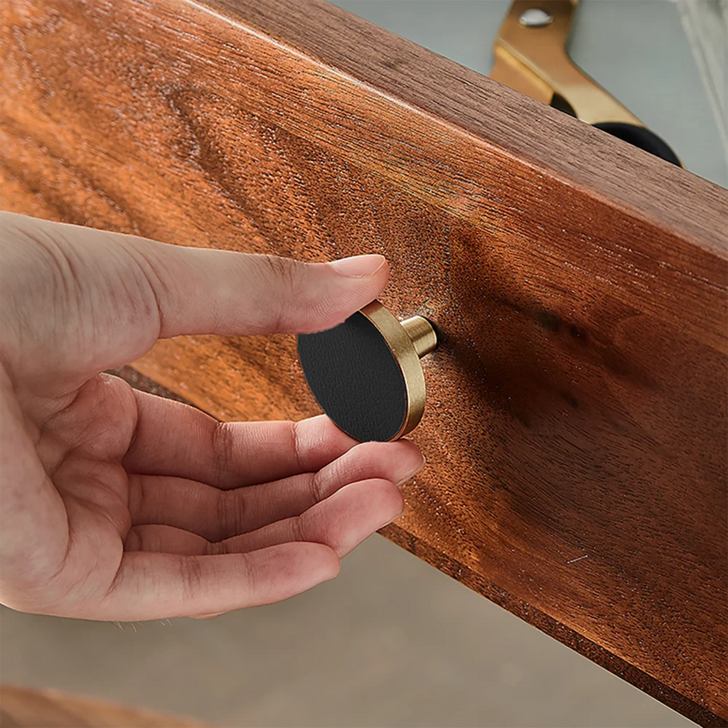 Brushed brass and leather round handle with elegant design, perfect for furniture or cabinetry from Brass Essence.