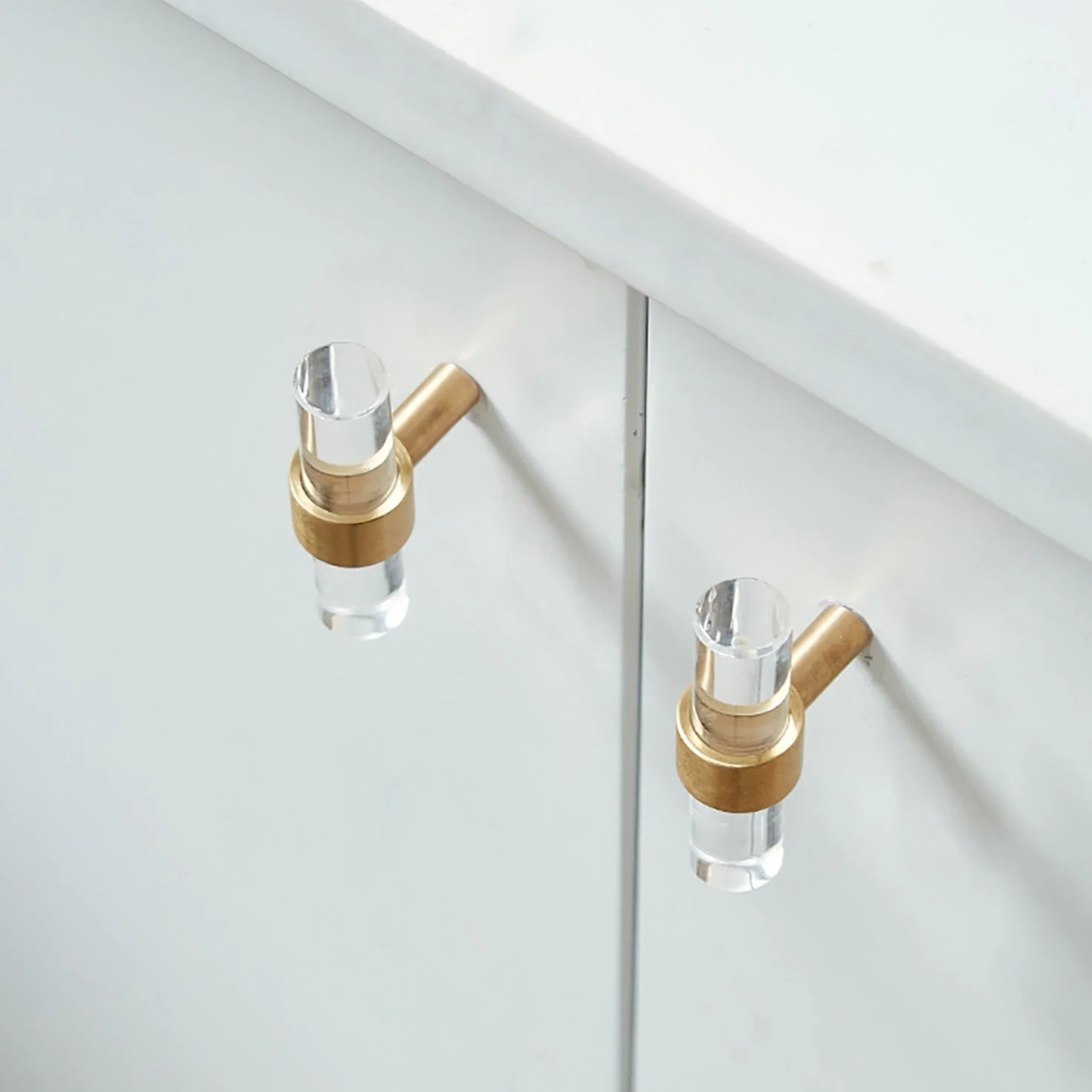 Clear acrylic and brass T-bar handle from Brass Essence collection, featuring sleek modern design and durable construction.