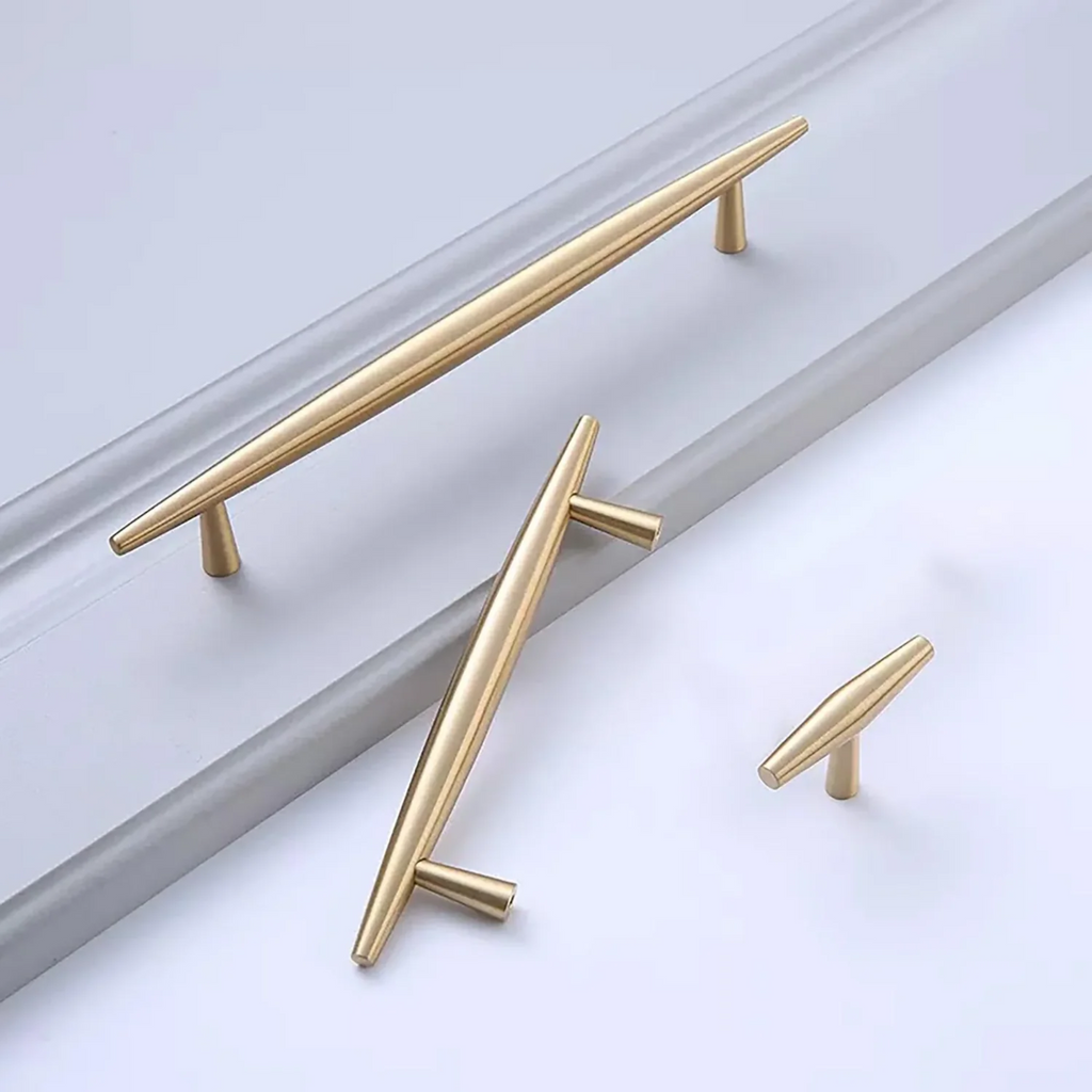 Brass Essence tapered brass cabinet pull with spindle design, featuring a smooth, polished finish for furniture or cabinetry.