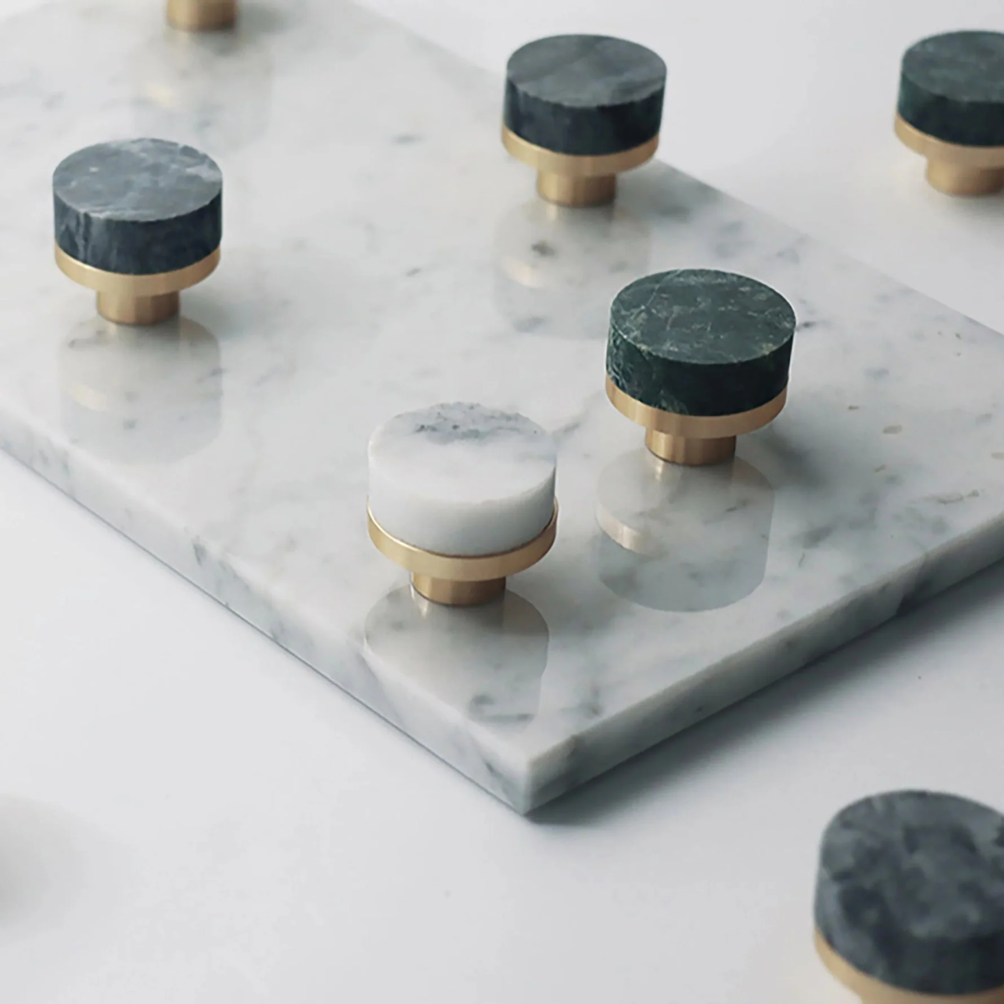 Pair of Karish marble and brass cabinet knobs with luxury finish from Brass Essence, featuring elegant marble accents and polished brass details.