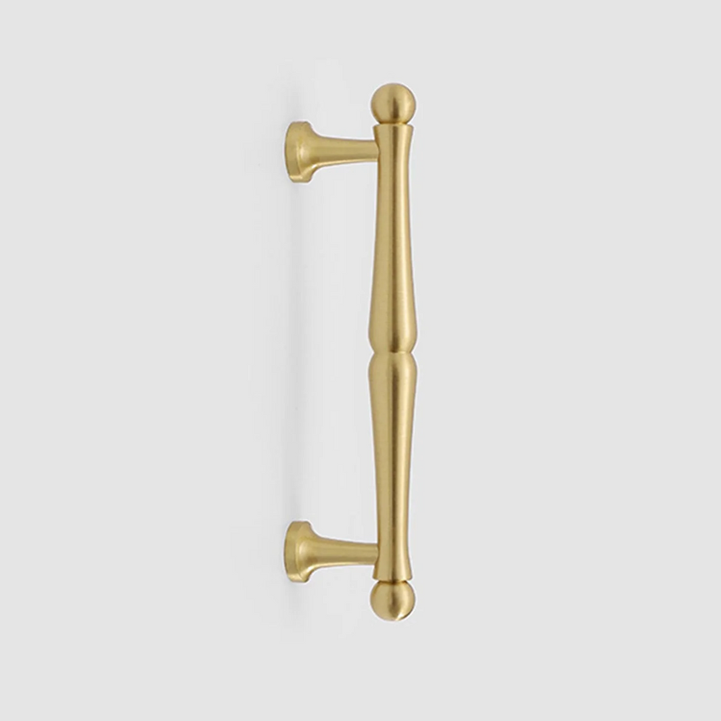 Nishilia tapered brass cabinet handle from Brass Essence, showcasing a sleek, polished brass finish and modern tapered design.