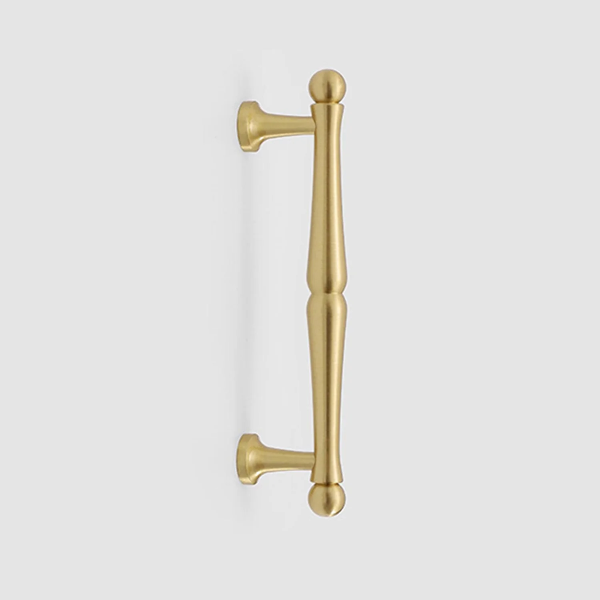 Nishilia tapered brass cabinet handle from Brass Essence, showcasing a sleek, polished brass finish and modern tapered design.