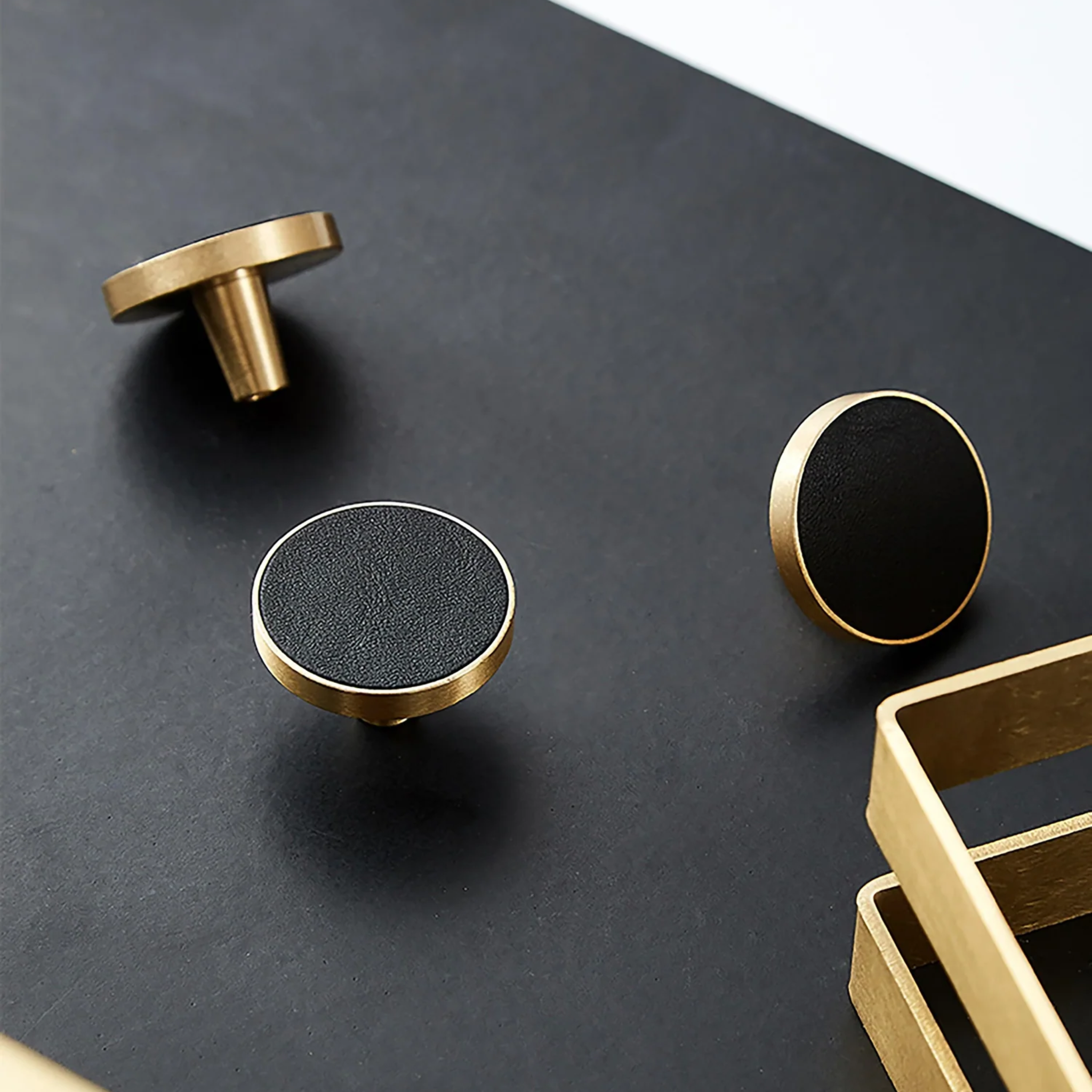 Brass Essence brushed brass and leather round handle, showcasing smooth brass surface and a leather grip on a modern furniture piece.