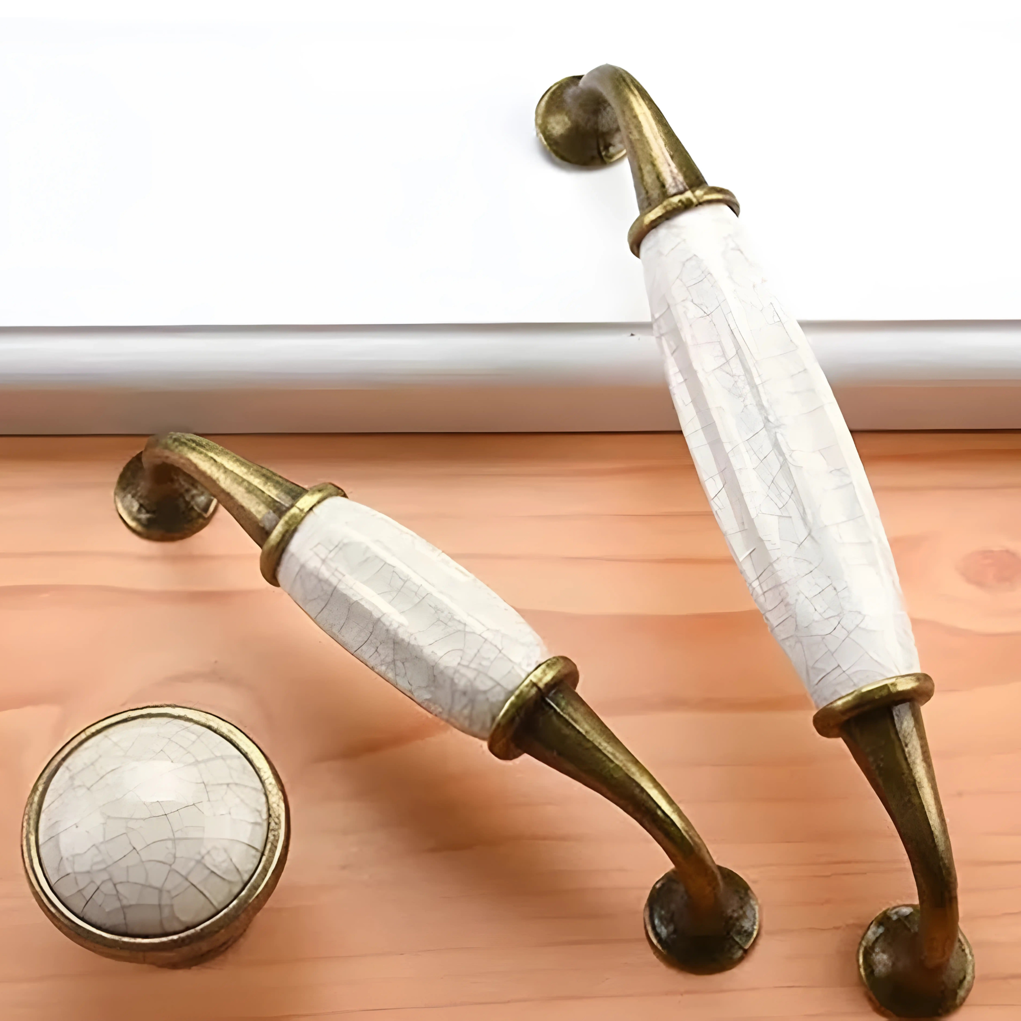 Antique ceramic and zinc cabinet handles by Brass Essence, featuring detailed designs and a vintage finish.