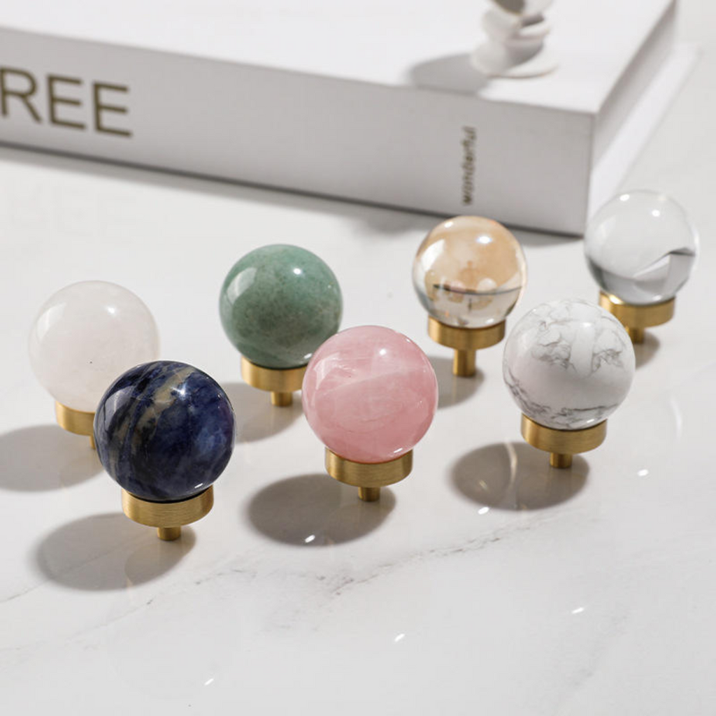 Brass Essence natural crystal ball and brass cabinet knob set, showcasing a polished crystal sphere and ornate brass hardware.