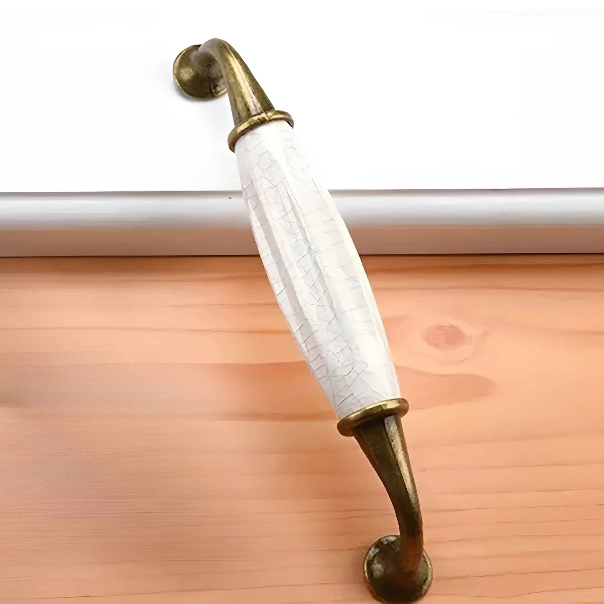 Antique brass ceramic and zinc cabinet handles with ornate design, ideal for vintage-style furniture or cabinetry.
