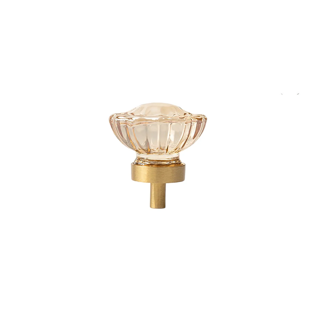 Faceted crystal and brass cabinet knob by Brass Essence, showcasing a elegant, shiny crystal with brass accents on a modern cabinet door.