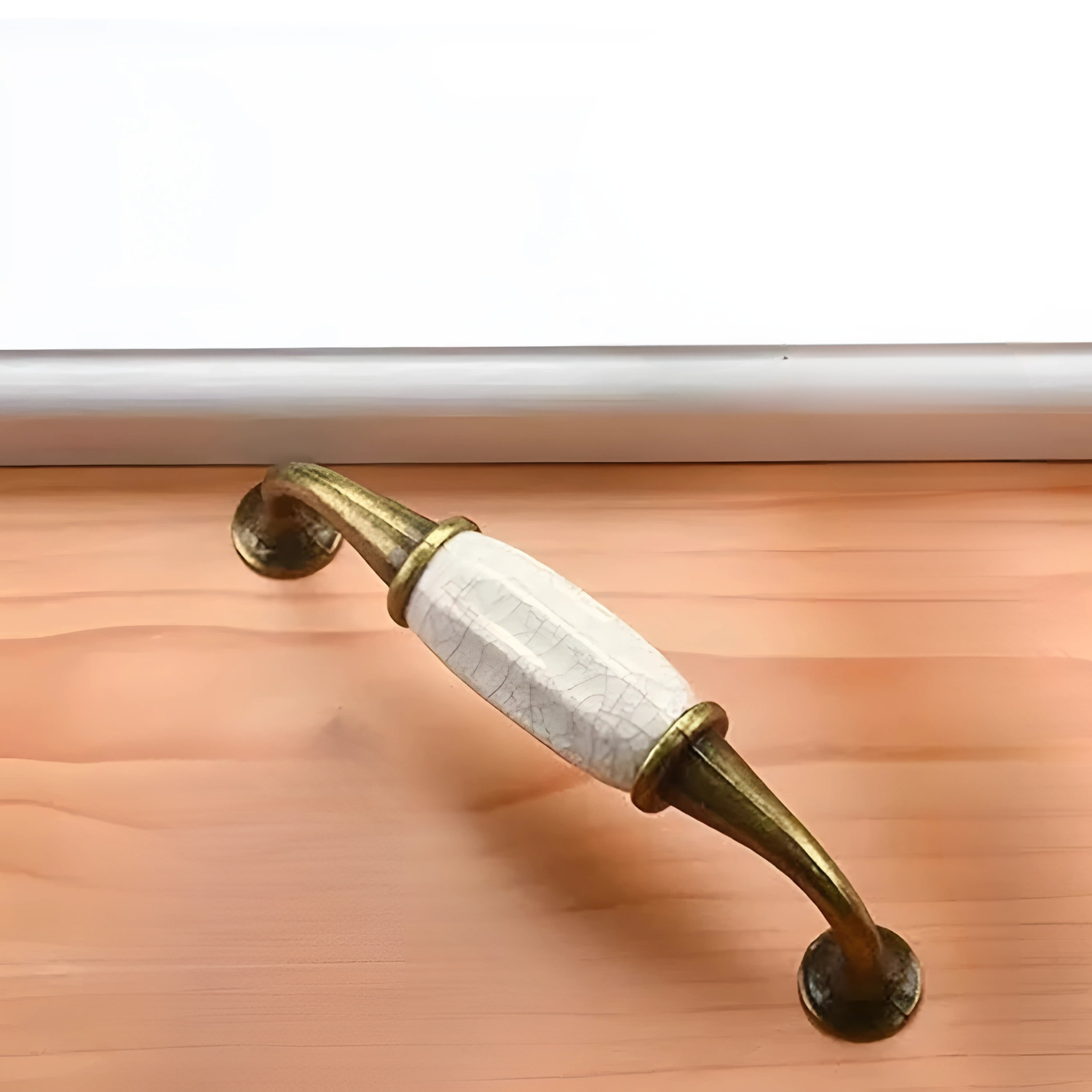 Antique Brass Essence ceramic and zinc cabinet handle with intricate design for vintage furniture accents.