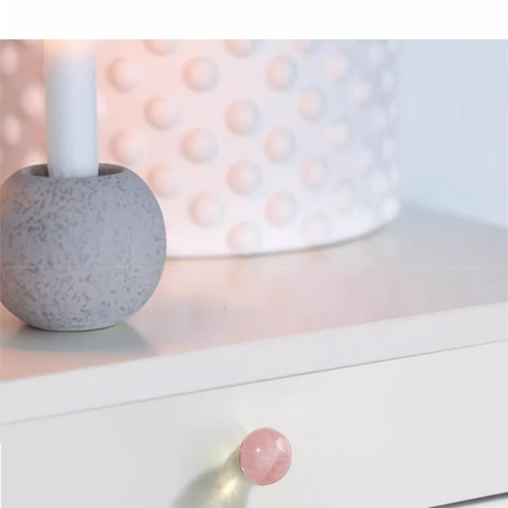 Brass essence natural crystal ball and brass cabinet knob, shiny round decorative hardware on a wooden surface.