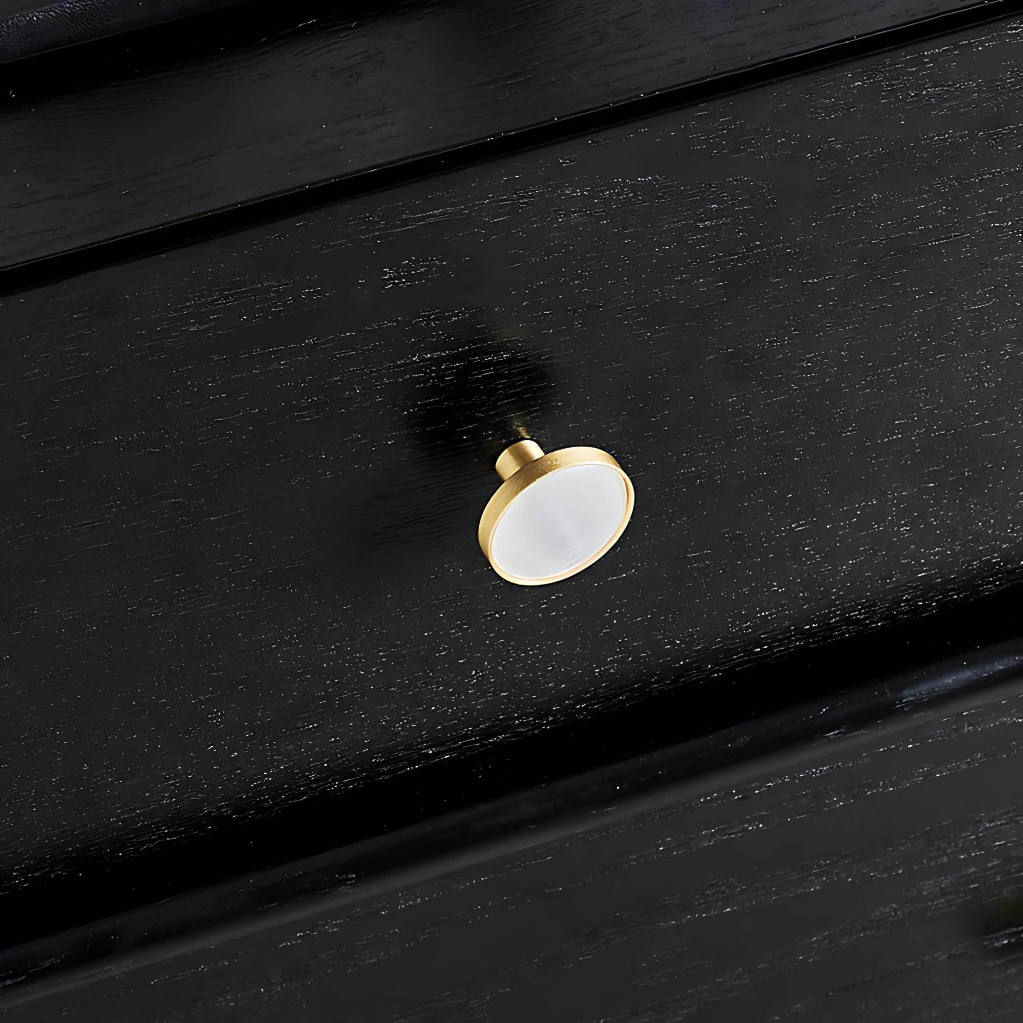 Mother of pearl and brass round cabinet knob by Brass Essence, showing a shiny pearl-inlaid surface with brass accents.