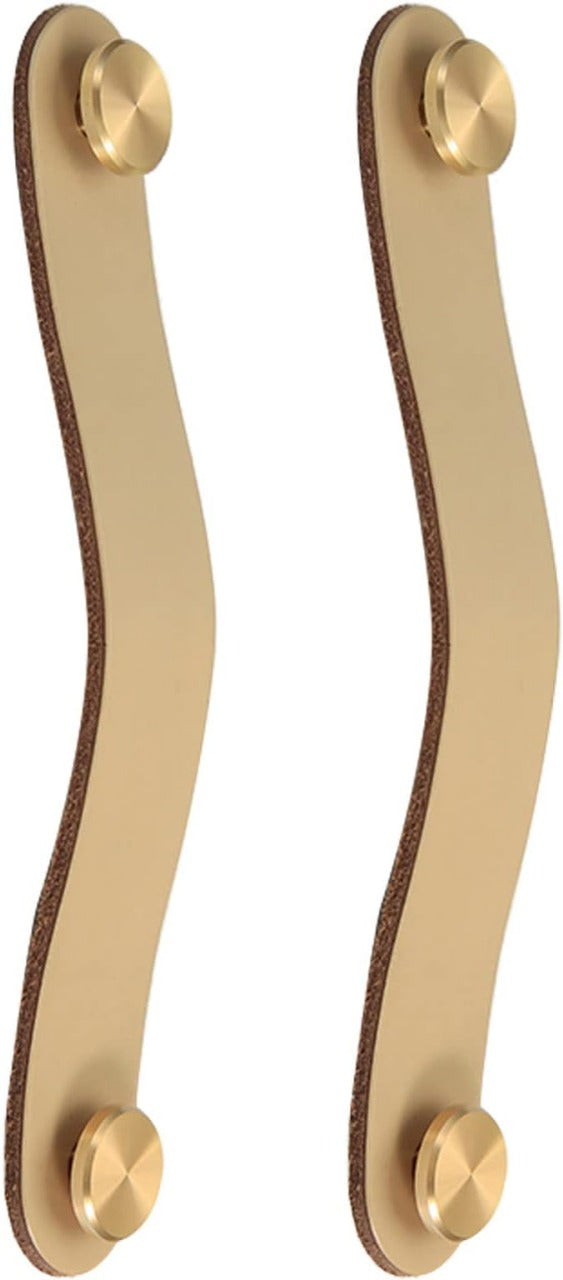 Brass essence leather and brass strap cabinet pulls mounted on a wooden cabinet, showcasing elegant hardware design.