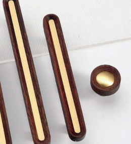 Brass essence brushed brass and Wenge wood handles featuring sleek design and natural wood grain on a modern furniture piece.