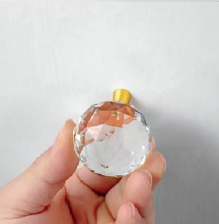 Faceted crystal and brass cabinet knob by Brass Essence, showing a close-up of the elegant, sparkling crystal with brass base.