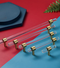 Clear acrylic and brass T-bar handle from Brass Essence, showcasing sleek modern hardware for furniture or cabinetry.