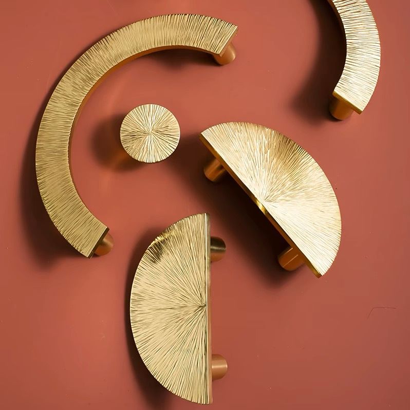 Pair of hammered brass half-circle pulls by Brass Essence, showing textured finish and elegant half-moon shape for furniture handles.