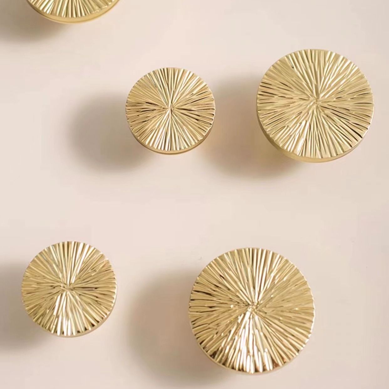 Pair of hammered brass half-circle drawer pulls from Brass Essence, featuring a textured finish and elegant design.