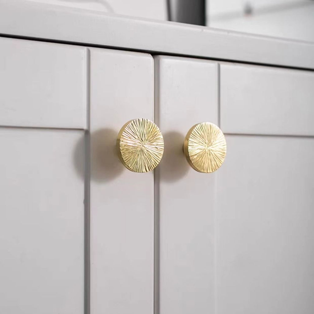 Pair of hammered brass half-circle pulls from Brass Essence, showing textured finish and sleek curved design for furniture or cabinets.